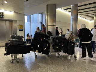 People with piles of luggage await flight details at Heathrow T4 (Maja Smiejkowska/PA)